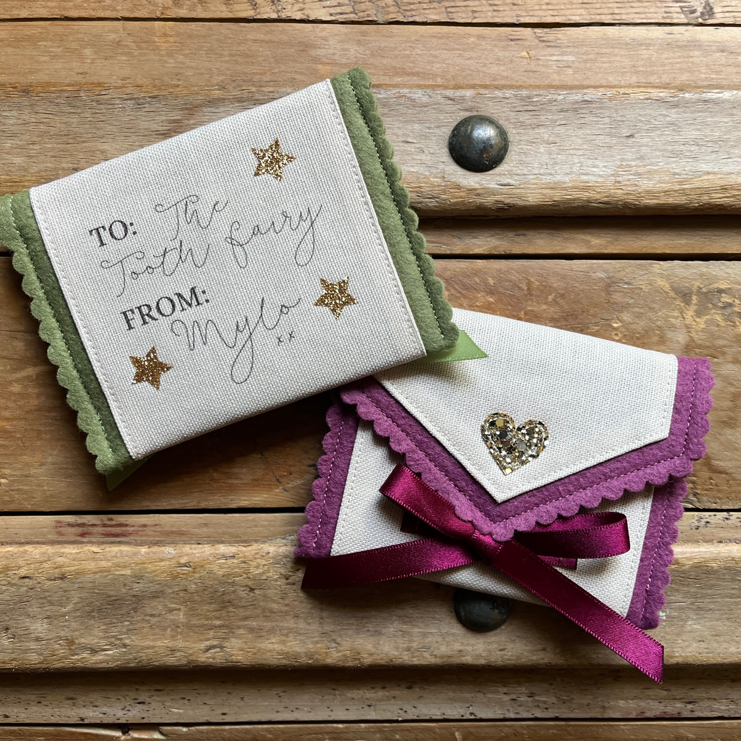 Decorative tooth fairy pouch with personalised text and star designs on a wooden surface