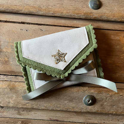 Decorative personalised tooth fairy pouch with glitter detail, ribbon fastening and scalloped edging. 