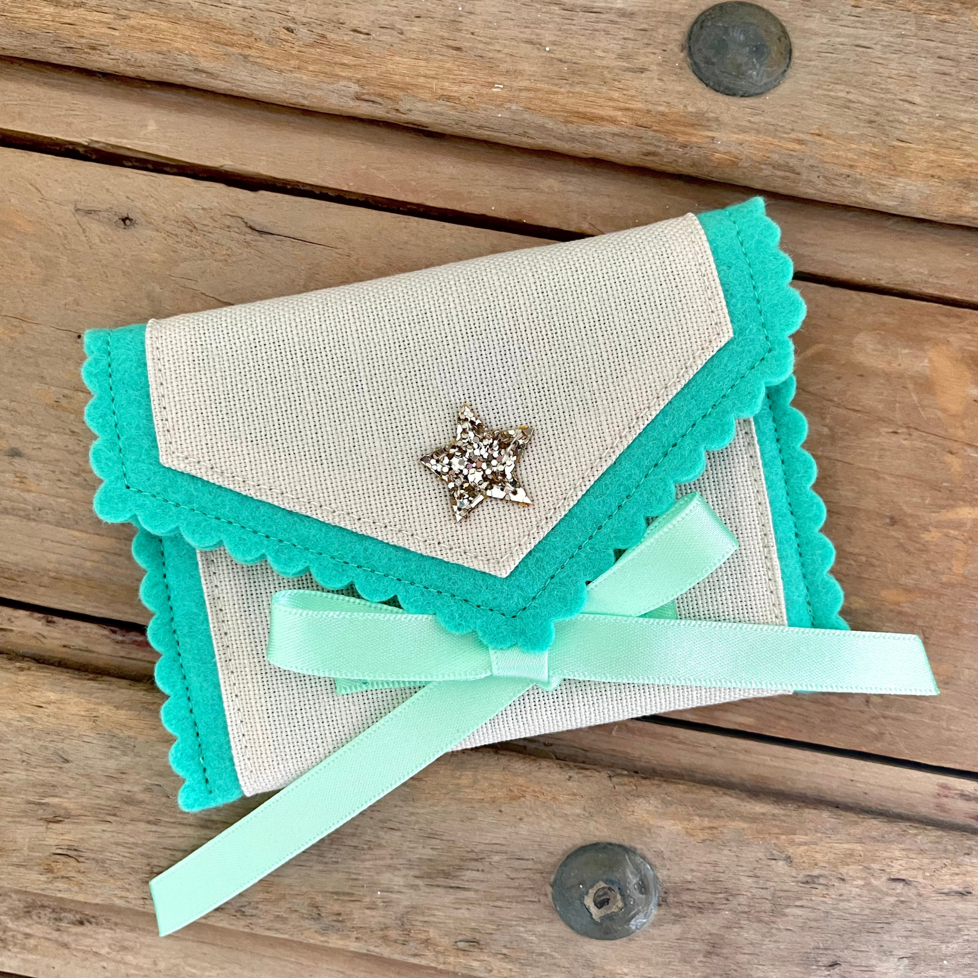 Decorative personalised tooth fairy pouch with glitter detail, ribbon fastening and scalloped edging. 