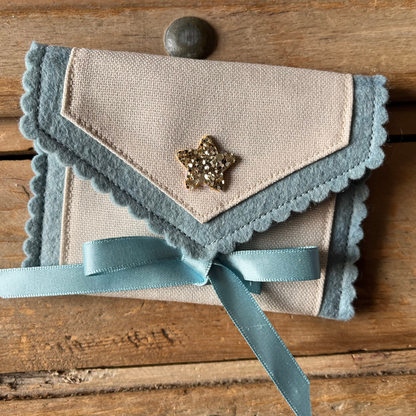 Decorative personalised tooth fairy pouch with glitter detail, ribbon fastening and scalloped edging. 