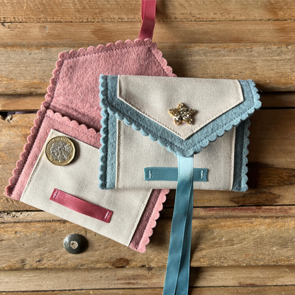 Decorative tooth fairy pouch with personalised text and star designs on a wooden surface showing ribbon tie