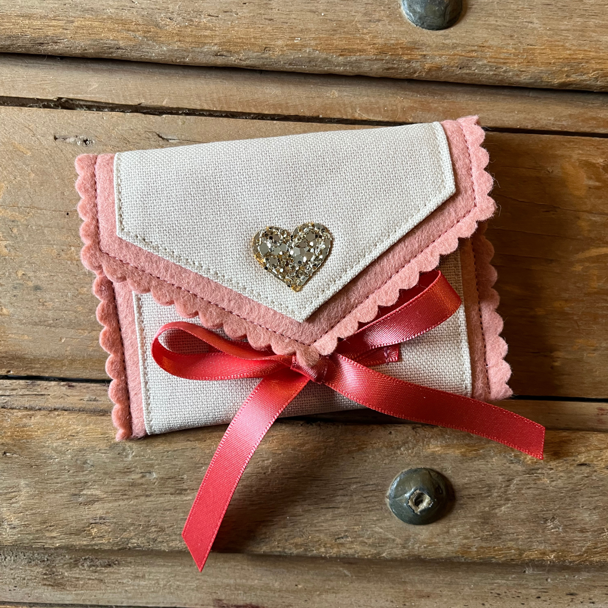 Decorative tooth fairy pouch with personalised text, star designs and ribbon fastening on a wooden surface