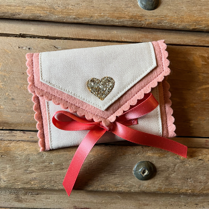 Decorative tooth fairy pouch with personalised text, star designs and ribbon fastening on a wooden surface