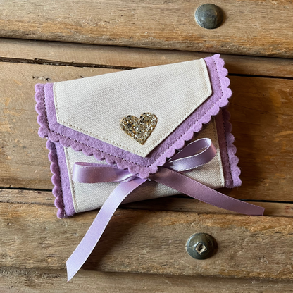 Decorative tooth fairy pouch with personalised text and star designs on a wooden surface